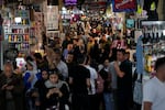 People walk through the old main bazaar of Tehran, Iran, on a Saturday night, Oct. 19, 2024.