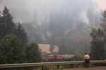 An officer looks on as fire crews work on the Eagle Creek Fire.