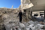 A woman looks through the remnants of an apartment building in Gaza on Saturday, March 9.