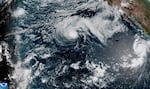 This satellite image released by NOAA shows Hurricane Fausto, center, and Hurricane Genevieve off the southwest coast of Mexico, right, over the Pacific Ocean, Sunday, July 26, 2026.