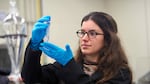FILE - Katie Moloney, a PhD student at the University of British Columbia and lead author on a study documenting the impact of runoff from artificial fields on coho salmon, measures out a water sample.
