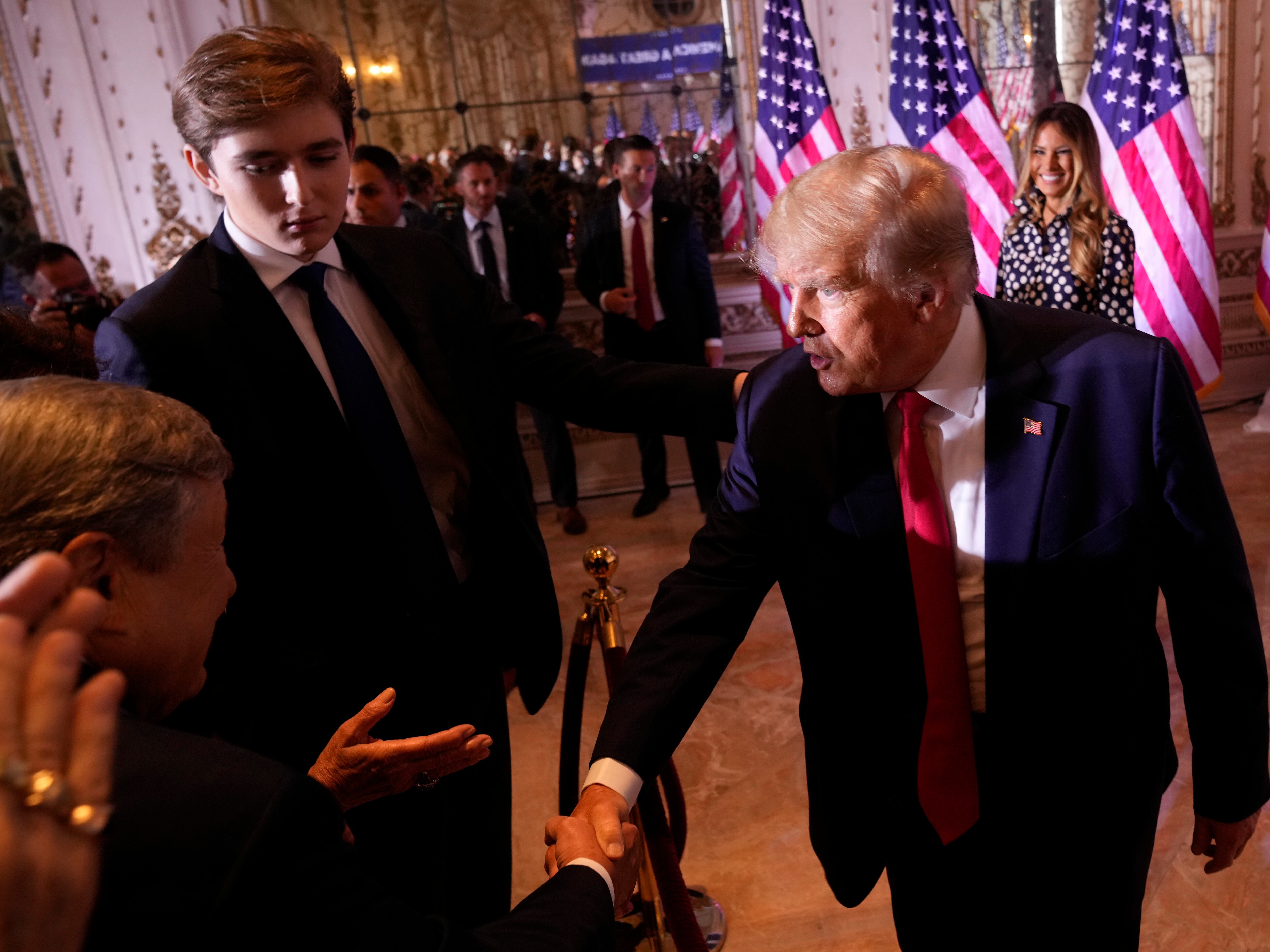 Former President Donald Trump greets people after announcing he is running for president for the third time as he speaks at Mar-a-Lago in Palm Beach, Fla., in 2022 as his son, Barron Trump, watches.