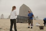 Valerie Schockelt (left) and Marc Ward use a microplastics filtration device to filter sand at Cannon Beach with iconic Haystack Rock in the background.