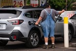 A person pumps gas at an Arco station on Belmont Street in Portland, Ore. on Tuesday, Nov. 25, 2025.