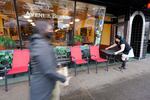 Bakery worker Eva Bernal carries a table from the sidewalk and back inside as the shop closes for the day Tuesday, Nov. 17, 2020, in Bellingham, Wash.