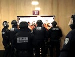 Police block an entryway to the Oregon Capitol as protesters attempt to gain access.