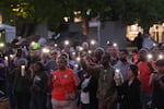 People hold smartphone with flash light during the vigil for victims the day after a shooting at Seattle Center during the Bite of Seattle food festival, Monday, July 27, 2026, in Seattle.