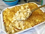 A pan of creamy macaroni and cheese studded with lumps of Dungeness crab