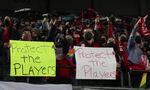 Portland Thorns fans hold signs that say "Protect the players" during the first half of the team's NWSL soccer match against the Houston Dash in Portland, Ore., Oct. 6, 2021.