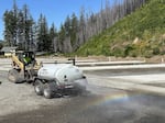 A contractor with Meili Construction uses a tractor to push a sprinkler through the construction site for the rebuilt Lazy Days Mobile Home & RV park, to keep down dust.