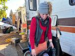 Stacey Hambrick loads her clothes into a garbage bag as she readies to leave an encampment on Clackamas Road on Sept. 30, 2024. Clackamas County ordered the road to be cleared and closed to the public.