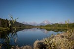 FILE - The Teton Mountains reflect on Oxbow Bend in Grand Teton National Park in Moran, Wyo., Aug. 22, 2025.