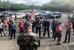 In this photo taken Sunday, June 23, 2019, a small crowd of local Republicans show their support of a Republican walkout outside the Oregon State Capitol in Salem, Ore. The gathering took place only a day after the Senate President ordered the statehouse to close over a "possible militia threat." 