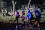 A Ukrainian woman looks at rescuers as they try to pull her out from under the rubble of a building after a Russian military strike on Kyiv, Ukraine, on Thursday. The strike occurred at 1 a.m., when most people were asleep. So far, nine people have been confirmed dead and more than 70 injured. The rescue operation is ongoing.