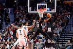 Portland Trail Blazers guard Shaedon Sharpe, center, drives to the hoop against Memphis Grizzlies forward Brandon Clarke, left, during the second half of an NBA basketball game Sunday, Nov. 10, 2024, in Portland, Ore.