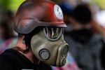 An antifascist protester wears a gas mask and helmet during a demonstration on the waterfront in Portland, Ore., Saturday, Aug. 17, 2019.