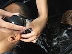 Ramani, 20, gets her hair washed by a recent graduate of the natural hair care program. Three participating students recently graduated with their natural hair care license, which they can use to get work once released.