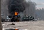 An armored personnel carrier burns and damaged light utility vehicles stand abandoned after fighting in Kharkiv, Ukraine, Sunday, Feb. 27, 2022. The city authorities said that Ukrainian forces engaged in fighting with Russian troops that entered the country's second-largest city on Sunday.