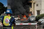 Cars burn after a rocket fired from the Gaza Strip hit a parking lot and a residential building in Ashkelon, southern Israel, Saturday, Oct. 7, 2023.