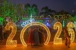 People pose for pictures near illuminated decorations on New Year's Eve in Mumbai, India 