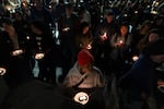 Mourners attend a vigil on Oct. 16, 2026, in downtown Bend, Ore.