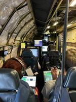 IMPACTS mission researchers inside the research plane, monitoring weather data being collected by onboard instruments.