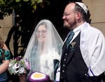 Ari and Lauren Douglas stand outside Congregation Beth Israel during their wedding in Portland, Ore., on June 15, 2025. More people are converting to Judaism following the Hamas attacks on Oct. 7, 2023, local Jewish leaders say.