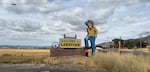 OPB's 'Weekend Edition' host Lillian Karabaic stands in front of the sign that says Welcome to Lakeview.