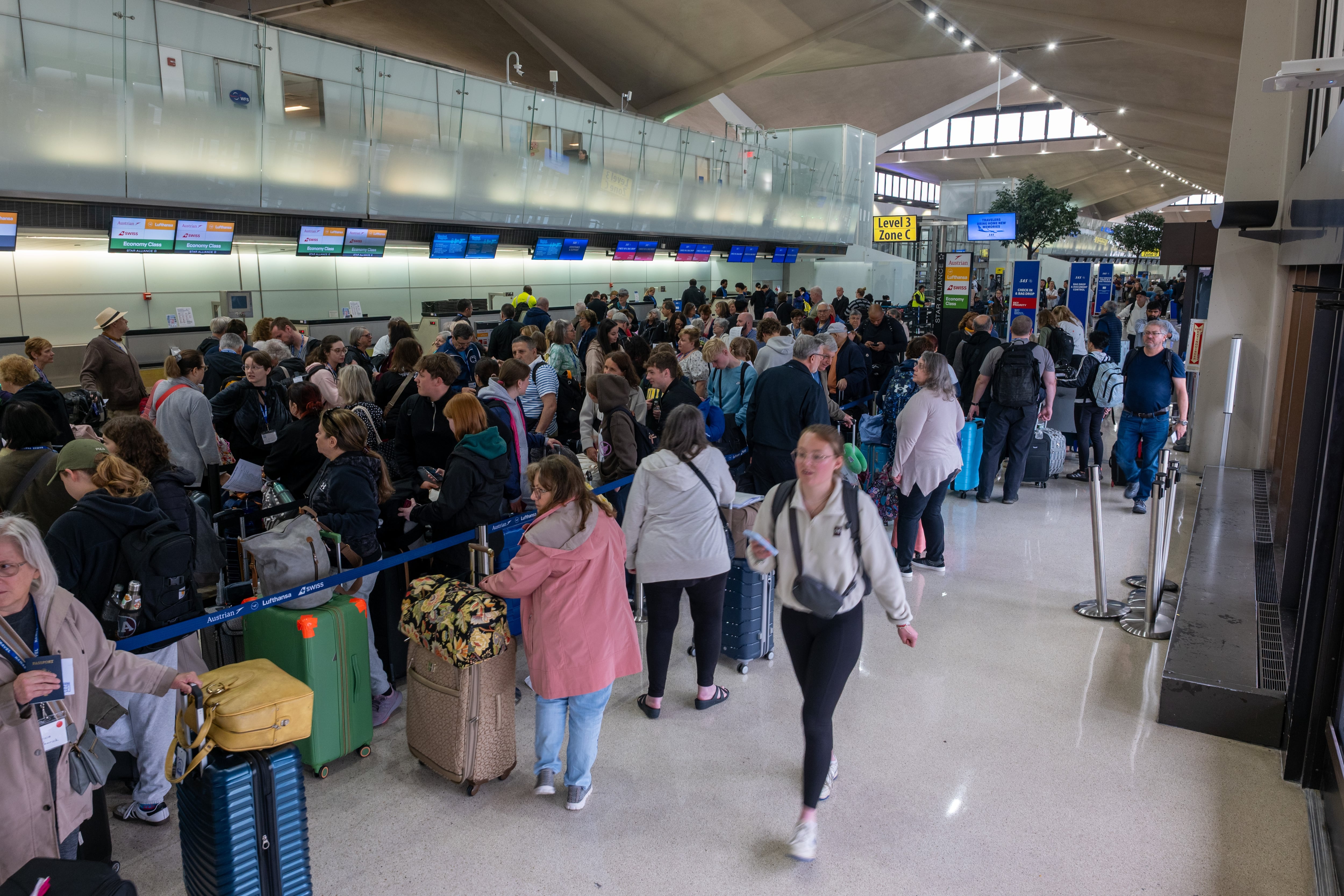 People wait in line at Newark Liberty International Airport in Newark, N.J. Air traffic control outages, runway construction and staffing shortages contributed to hundreds of delays and cancellations.