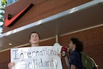 Eloise Erickson, left, protests outside the Nike Community Store in Northeast Portland.