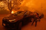 Tuesday, Jan. 7: A woman cries as flames advance in the Pacific Palisades neighborhood of Los Angeles.