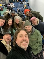 KMHD crouched in a selfie huddled together at a gate at the Portland airport.