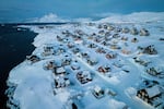 Houses covered in snow are seen on the coast of a sea inlet of Nuuk, Greenland, March 7, 2025.