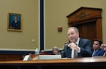 EPA Administrator Lee Zeldin sits at a wooden table equipped with a microphone as he testifies before the House Committee on Energy and Commerce's Subcommittee on Environment in May 2025.