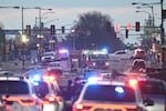 As the sun rises Saturday morning, the aftermath of destruction is seen outside the Roosevelt Mall after a small plane crashed in Philadelphia Friday night.