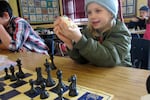 Dude shows off chess pieces captured from his sister Daisy Jane during SUN after school program.