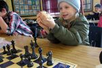 Dude shows off chess pieces captured from his sister Daisy Jane during SUN after school program.