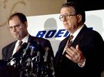 McDonnell Douglas CEO Harry Stonecipher, left, and Boeing CEO Phil Condit meet reporters in Washington on July 23, 1997, to discuss the European Union's approval of their companies' merger.