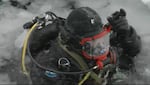 Videographer Michael Bendixen intentionally dives into a frozen lake with the Klamath County Dive Search & Rescue Team