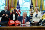President Donald Trump holds an executive order relating to education in the Oval Office of the White House, Wednesday, April 23, 2025, in Washington, as Commerce Secretary Howard Lutnick, Labor Secretary Lori Chavez-DeRemer and Education Secretary Linda McMahon watch.