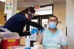 Multnomah County Public Health Nurse Maren Peters gives Veikoso Moala a COVID-19 vaccine, April 1, 2021, at a clinic hosted by Transition Projects' Clark Center Shelter. 