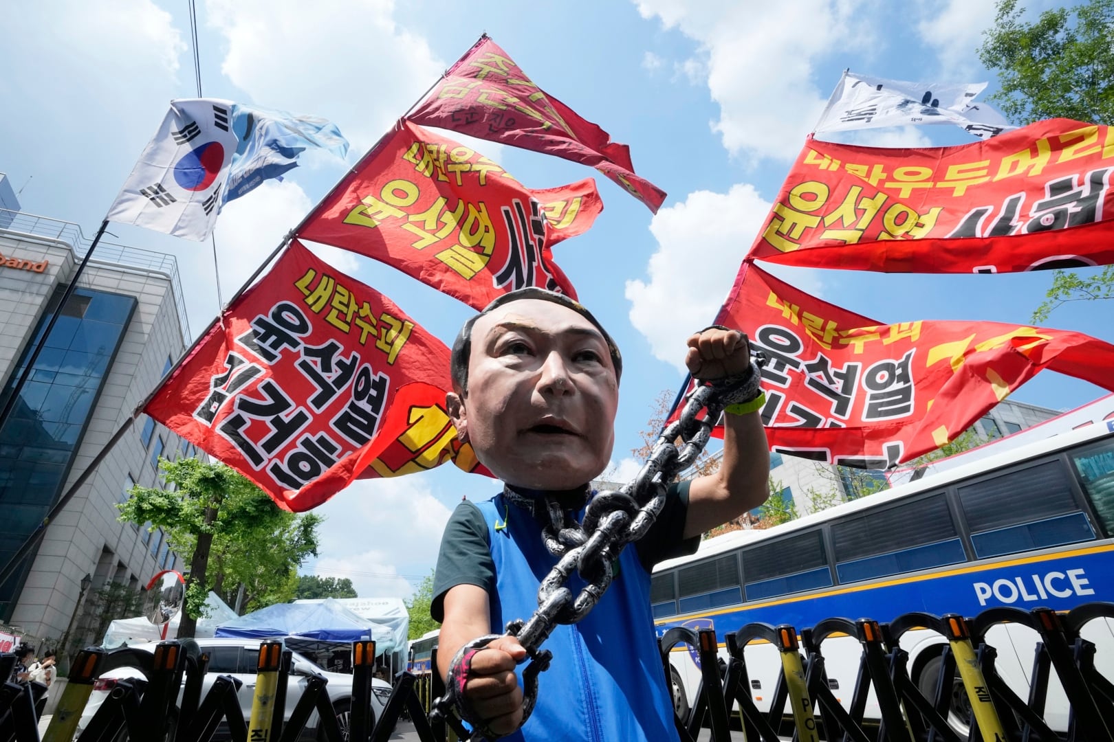 A protester wears a mask of former South Korean President Yoon Suk Yeol during a rally in support of a hearing to review a special prosecutor's request for his arrest, near the Seoul Central District Court in Seoul, South Korea, on Wednesday, July 9, 2025. The writing reads