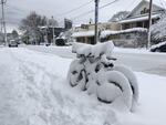 Bikes locked up under inches of packed snow in Portland.