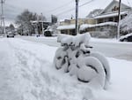 Bikes locked up under inches of packed snow in Portland.