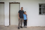 Suliman Mleihat, 32, and his 9 year old son Obeida stand in front of Obeidas classroom. Where he sheltered from settlers that had attacked the school in the Mu'ajarat Bedouin Community, Palestine, on September 18, 2024. Israeli settlers attacked teachers with bats and tried to break into classrooms where students were sheltering a few days previously, they then went on to attack people in the rest of the village and stole a horse. Maya Levin for NPR