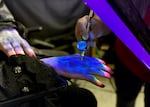 Backstage is filled with people half-transformed into creepy little creatures. Shell Galloway has her turn in the chair of professional FX artist Christina Kortum, who spends 20 minutes airbrushing Galloway’s face and hands into a blacklight-activated vampire.