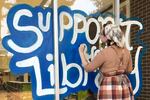 Messages on the window of the Craighead County Jonesboro Public Library in Jonesboro, Ark., urged voters to approve library funding. Local voters opted to cut the funding in half, following complaints about books that some deemed inappropriate, and the library is now struggling to stay open.