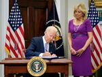 President Biden signs into law the Bipartisan Safer Communities Act gun safety bill, in the Roosevelt Room of the White House on Saturday as first lady Jill Biden looks on.