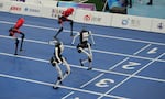 Humanoid robots compete in the 100m final race during the World Humanoid Robot Games in Beijing, Wednesday, Aug. 26, 2026.