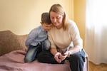 Bohdan Semenukha and his mom, Viktoria, look at photos from before the invasion.